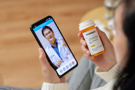 Consulting doctor visit on mobile app at home.telemedicineの写真素材