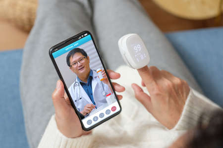 Consulting doctor visit on mobile app at home.telemedicineの写真素材