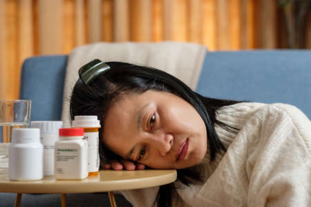 asian woman get headache and feel sick at homeの写真素材