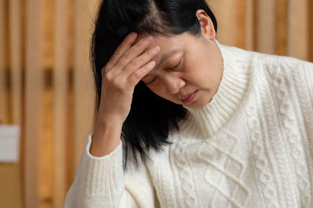 asian woman get headache and feel sick at homeの写真素材