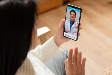 Consulting doctor visit on mobile app at home.telemedicineの写真素材