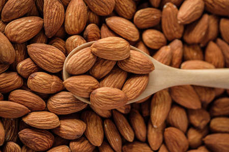 Almonds in wood bowl on wood table.Diet raw materialの写真素材