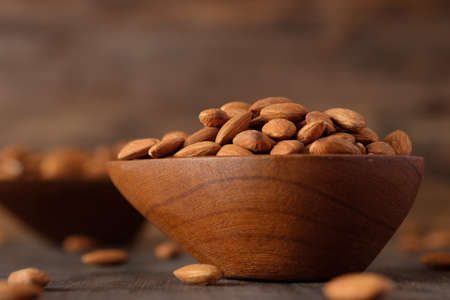 Almonds in wood bowl on wood table.Diet raw materialの写真素材