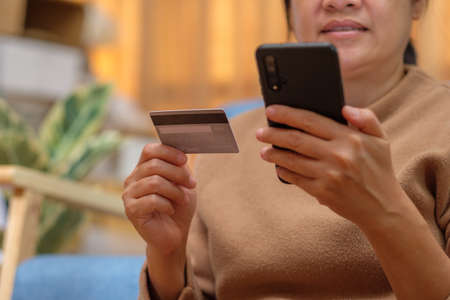 close up hand use credit card pay contactless online in mobile app shoppingの写真素材