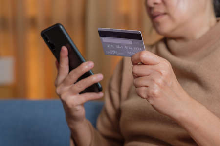 close up hand use credit card pay contactless online in mobile app shoppingの写真素材