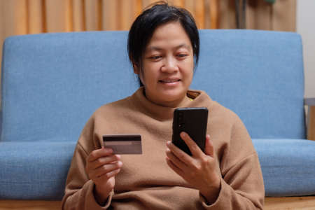 close up hand use credit card pay contactless online in mobile app shoppingの写真素材