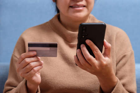 close up hand use credit card pay contactless online in mobile app shoppingの写真素材