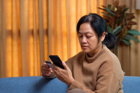 close up hand use credit card pay contactless online in mobile app shoppingの写真素材