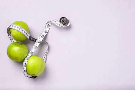 top view group of green apple with tape measure on pastel purple tableの写真素材