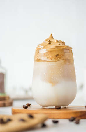 Dalgona coffee with fluffy cream served on wood tray.Homemade trendy beverage menu on social mediaの写真素材