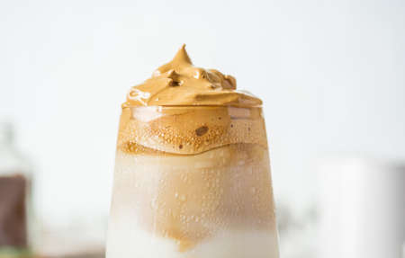Dalgona coffee with fluffy cream served on wood tray.Homemade trendy beverage menu on social mediaの写真素材