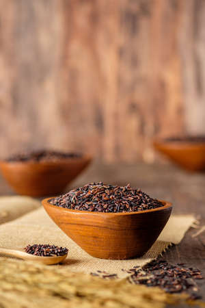 riceberry rice in wooden bowl on wood tableの写真素材