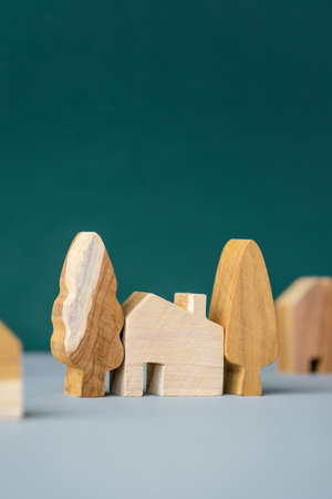 set of wooden house and tree decoration in village on grey floor and green backgroundの写真素材