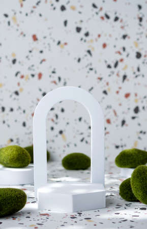 White geometric pedestal on terrazzo background with summer sunlight and green moss rockの写真素材