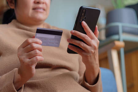 close up hand use credit card pay contactless online in mobile app shoppingの写真素材