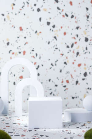 White geometric pedestal on terrazzo background with summer sunlight and green moss rockの写真素材