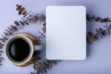 blank poster with coffee cup with eucalyptus leaves on pastel violet background