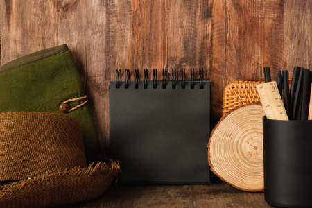 blank black sprial notebook diary with travel stuff on wood tableの写真素材