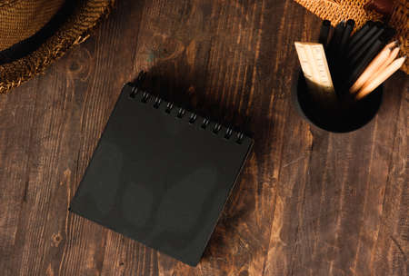 blank black sprial notebook diary with travel stuff on wood tableの写真素材