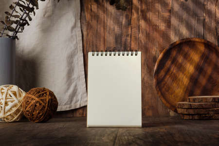 blank notebook recipe with kitchenware on wood table with sunlightの写真素材