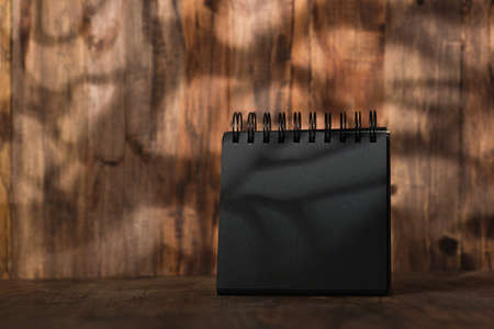blank black sprial notebook diary with travel stuff on wood tableの写真素材