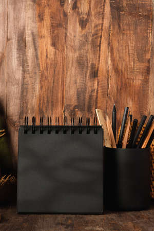 blank black sprial notebook diary with travel stuff on wood tableの写真素材