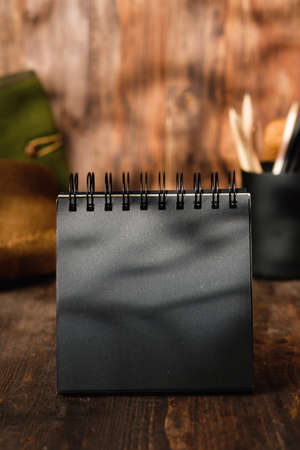 blank black sprial notebook diary with travel stuff on wood tableの写真素材
