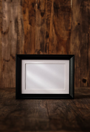 blank black photo frame on wood table and wall witn sunlight from windowの写真素材