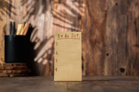 brown note paper to do list on wood wall and pencil box with sunlight