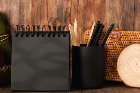 blank black sprial notebook diary with travel stuff on wood tableの写真素材