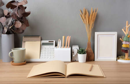 open kraft book on wood table with stationeryの写真素材