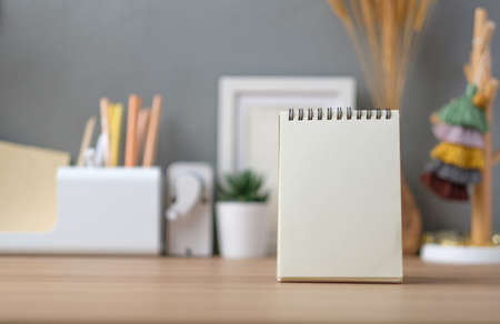 sprial note pad with stationery stuff on working desk at home