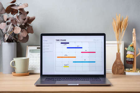 timetable project on screen laptop on working desk decor with stationery at homeの写真素材