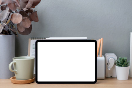 Blank screen tablet on working desk decor with stationery at homeの写真素材