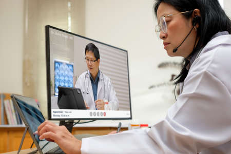Asian woman doctor video conference discussion with doctor team about diagnosis patient symptom