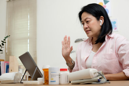 asian woman telemedicine doctor online visit with virtual reality technology vr glasses at homeの写真素材