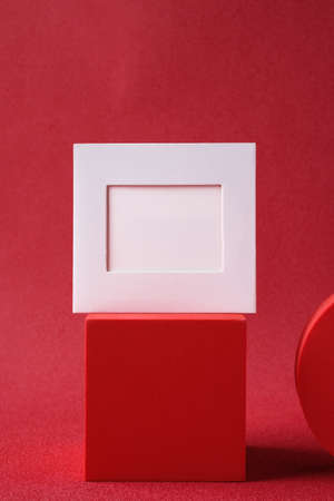 blank business card on pedestal on vivid red background studioの写真素材