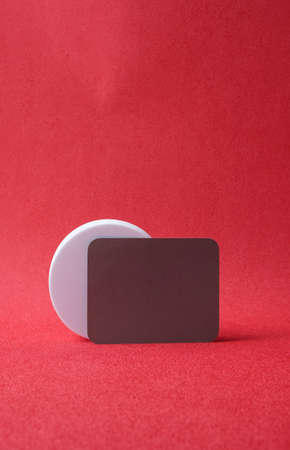 gery business card on pedestal on vivid red bacground studio
