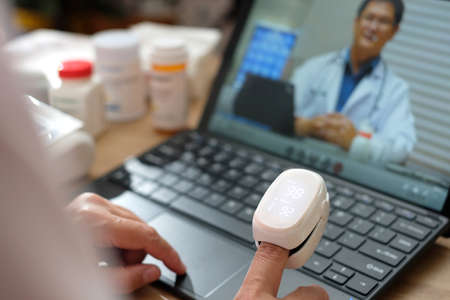 asian woman telemedicine doctor online visit with computer at home