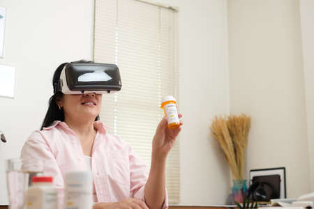 asian woman telemedicine doctor online visit with virtual reality technology vr glasses at homeの写真素材