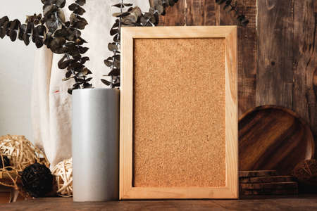 blank corkboard with kitchenware on wood table with sunlightの写真素材