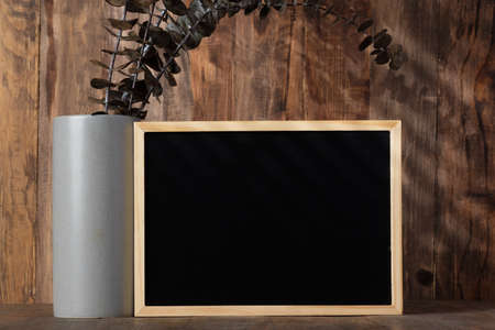blank blackboard frame with kitchenware on wood table with sunlightの写真素材