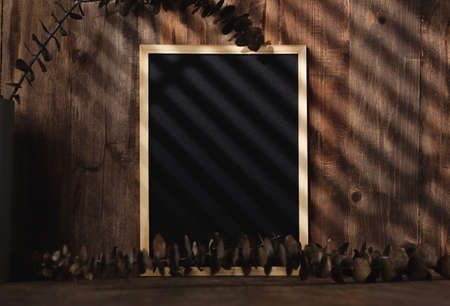 blank blackboard frame with kitchenware on wood table with sunlightの写真素材