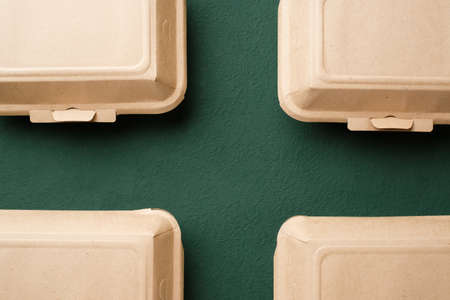 Recycle Eco-friendly disposable food container made of kraft paper on a green backgroundの写真素材