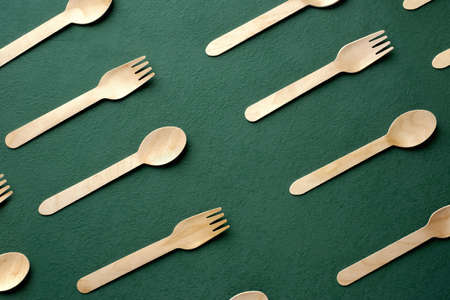 Plastic free set bamboo spoon and fork on dark green background.Zero waste disposable kitchen ware