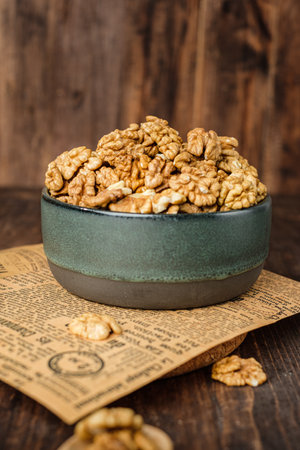 walnut in ceramic bowl on kitchen wooden tableの写真素材