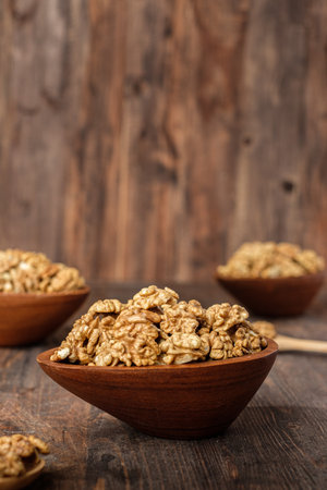 walnut in wood bowl on kitchen tableの写真素材