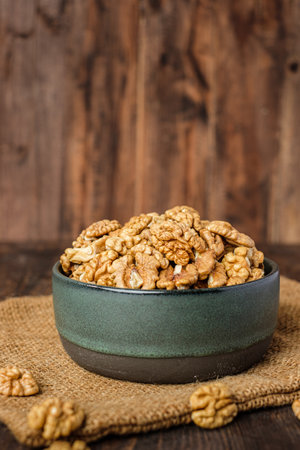 walnut in ceramic bowl on kitchen wooden tableの写真素材