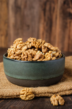 walnut in ceramic bowl on kitchen wooden tableの写真素材