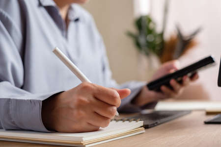 asian woman use mobile while video conference meeting online with tablet at homeの写真素材